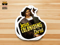 A stack of die-cut stickers featuring a parody art print of Jesus Christ dressed as Christopher Columbus, with the bold yellow text 'Jesus Colonizing Christ'. The stickers are displayed on a light wood grain background, with a 'Snarky Brown Studio' logo in the top-left corner.