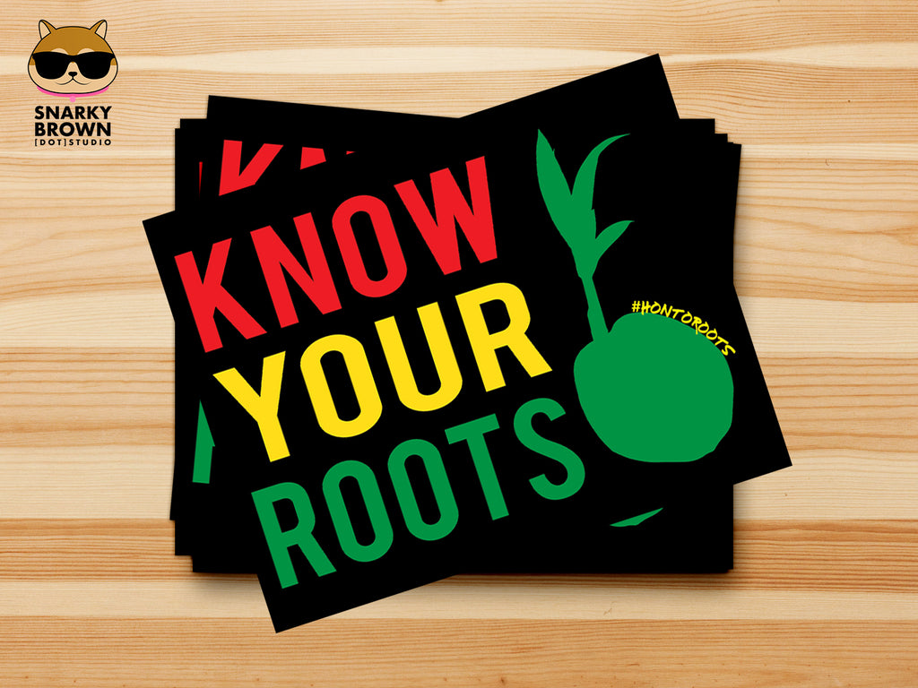 A stack of black stickers with the phrase 'KNOW YOUR ROOTS' in large red, yellow, and green letters, plus a green coconut sprout graphic, displayed on a light wood background. A Snarky Brown Studio logo appears in the top-left corner.