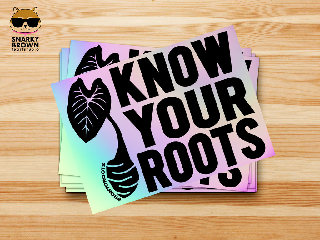A pile of rectangular stickers with an iridescent holographic background and bold black text reading 'KNOW YOUR ROOTS,' each accompanied by a black taro root graphic.